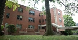 large red-brown building with covered entry